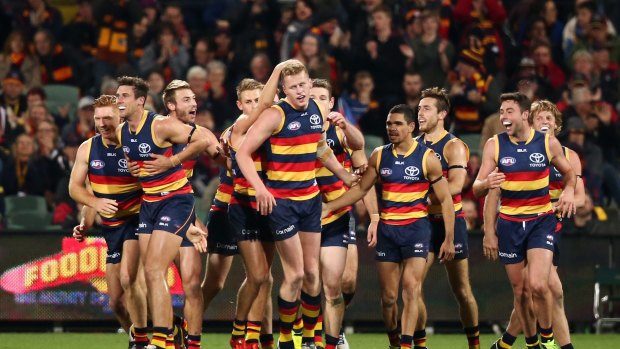 ADELAIDE, AUSTRALIA - AUGUST 06: Adelaide players congratulate teammate Reilly O'Brien after he kicked his first goal during the round 20 AFL match between the Adelaide Crows and the Brisbane Lions at Adelaide Oval on August 6, 2016 in Adelaide, Australia.  (Photo by Morne de Klerk/Getty Images)