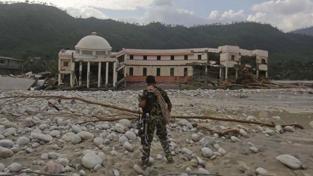 A member of the Indian army's rescue team walks towards the officers' training centre damaged by floods at their campus in Srinagar.