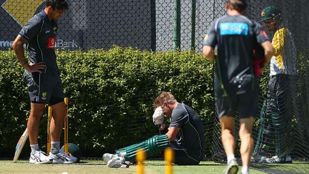 David Warner is disconsolate after being struck on the left hand by Mitchell Johnson during training session at the WACA.