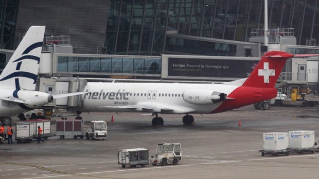 Baggage carts make their way past a Helvetic Airways aircraft from which about $50 million worth of diamonds were stolen on the tarmac of Brussels international airport Tuesday, Feb. 19, 2013.