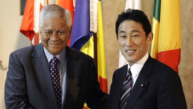 Philippine Foreign Affairs Secretary Albert del Rosario, left, poses with his Japanese counterpart Fumio Kishida for photographers during a visit to the Department of Foreign Affairs.