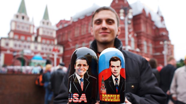 A souvenir seller in Moscow holds matryoshka dolls painted with portraits of presidents Barack Obama and Dmitry Medvedev.   