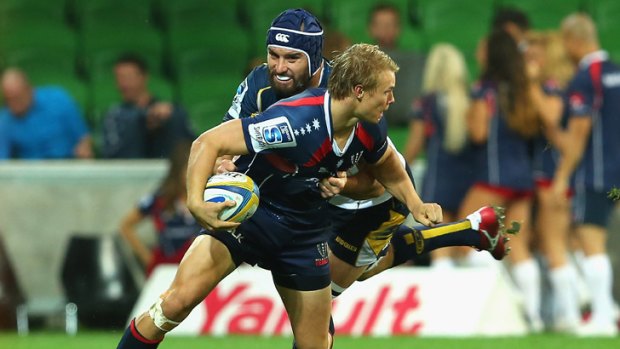 Melbourne Rebel's Tom Kingston attempts to fend off a tackle from the Brumbies'  Scott Fardy.