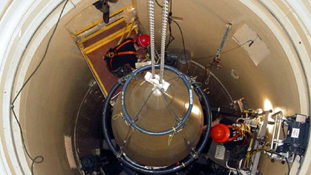 A Malmstrom Air Force Base missile maintenance team removes the upper section of a Minuteman 3 intercontinental ballistic missile at a Montana site.