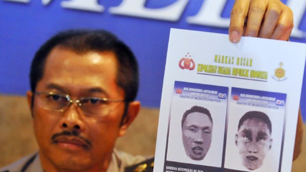 Indonesian police spokesman Nanan Sukarna shows images of the suicide bombers.