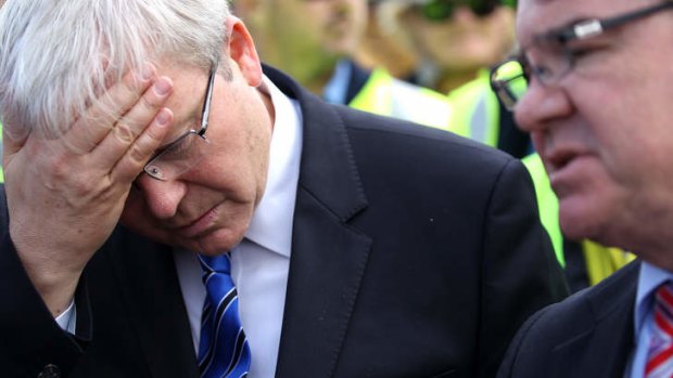 Australian Prime Minister, Kevin Rudd holds his head as Labor MP Gary Gray looks on.