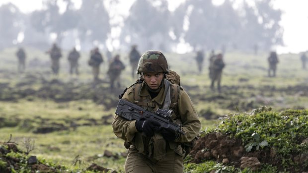 An Israeli soldier from the Golani brigade takes part in training near the city of Katzrin in the Israeli-occupied Golan Heights. An Israeli helicopter strike in Syria killed a commander from Iran's Revolutionary Guard and the son of the group's late military leader Imad Mughniyeh, Hezbollah said.