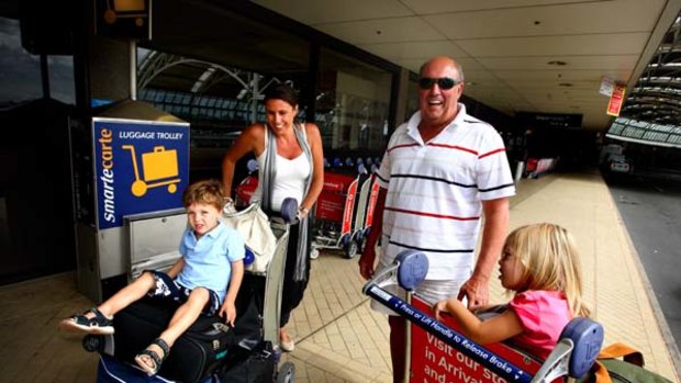 Bring your money with you ... Victoria Bourke, accompanied by her children Charlie, 3, and Eva, 2, and her father, Chris Sharples, at Sydney airport.