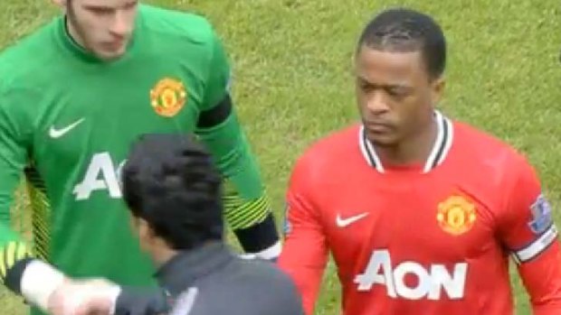 Controversial ... Luis Suarez, front, walks past Patrice Evra, right, without shaking his hand.