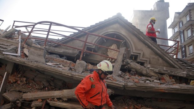 A Mexican rescue worker stands at the site of a building that collapsed in a second earthquake in Kathmandu, Nepal.