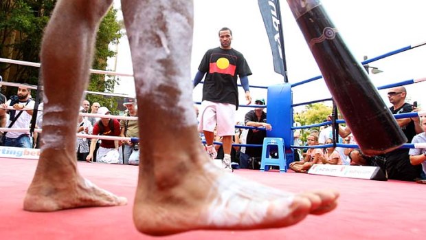 Rhythm and blue ... Anthony Mundine watches a didgeridoo player during a title fight promotion at Circular Quay.
