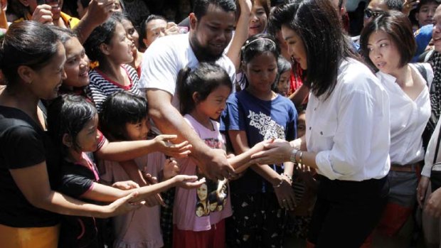 Thailand's Prime Minister Yingluck Shinawatra greets people as she visits a flooded area in Nonthaburi province on the outskirts of Bangkok.