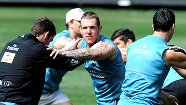 Dane Swan stretches at Collingwood's training session at the MCG yesterday. It was a contrast to last week's public sessions at Gosch's Paddock, which attracted thousands of fans.
