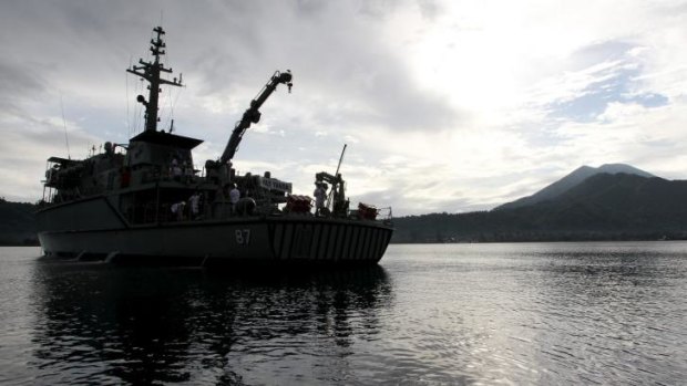 The HMAS Yarra off Rabaul on Wednesday. Wreaths and flowers were thrown overboard in a dawn service marking 100 years since the AE1 disappeared without trace.