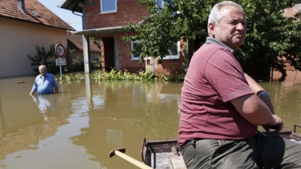 Bosnian people distribute food and water to residents who remained in their flooded houses in the Bosnian village of Domaljevac.