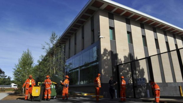 Members of the ACT SES attend a job at the Royal Australian Mint, where a sudden wind storm lifted tiles from the roof and sent debris crashing into cars.