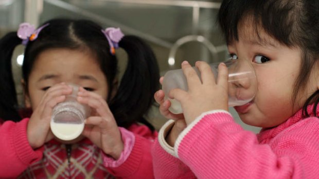 Two young girls drink milk at a kindergarten in Shanghai.