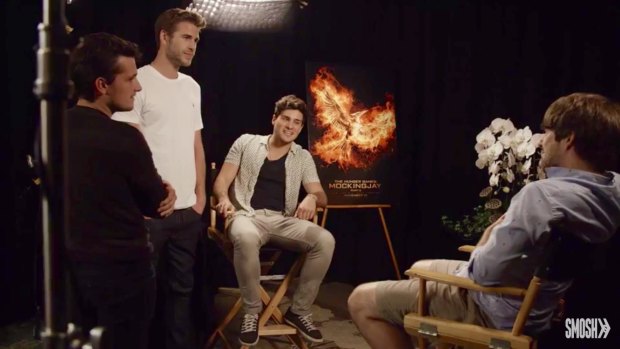 Liam Hemsworth and Josh Hutcherson stand over the Smosh team after Jennifer Lawrence's prank during an interview for <i>The Hunger Games: Mockingjay - part 2</i>.