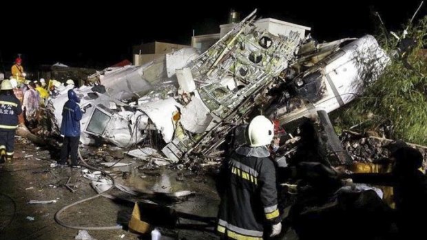 Rescue workers survey the wreckage of TransAsia Airways flight GE222, which crashed while attempting to land in stormy weather on the Taiwanese island of Penghu, late on Wednesday.