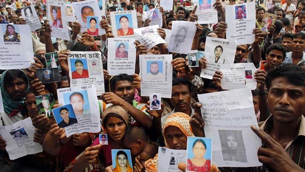 Faces of the fallen: Relatives show pictures of workers believed trapped under the rubble of Rana Plaza.
