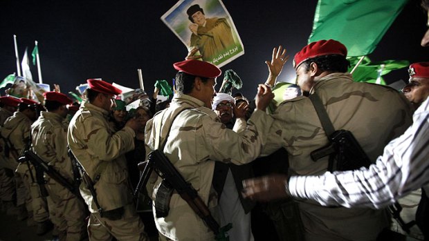 Soldiers join thousands of Gaddafi supporters serving as human shields against possible air strikes by allied forces directed at his compound in Tripoli.