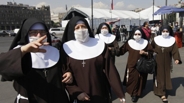 Taking no chances: Nuns wearing surgical masks, protecting them from swine flu, walk through Zocalo plaza in Mexico City.