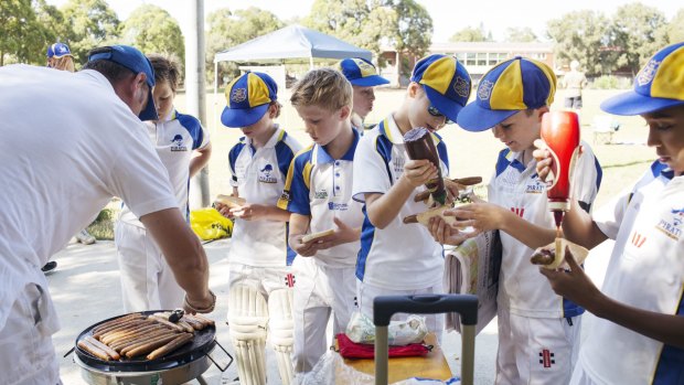 After the match: Under 11s hit the sausage sizzle. 