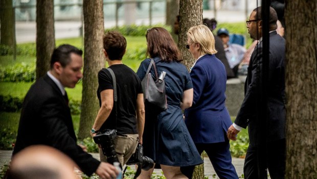 Hillary Clinton (right) is seen leaving the 9/11 ceremony early.