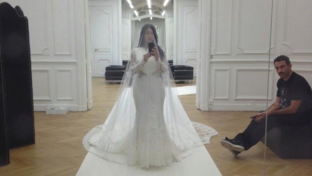 Kardashian trying on her wedding dress before tying the knot with Kanye West in May, 2014.