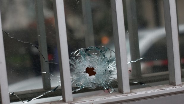 A bullet hole is seen in a window of a building next to the French satirical magazine Charlie Hebdo's office, in Paris.