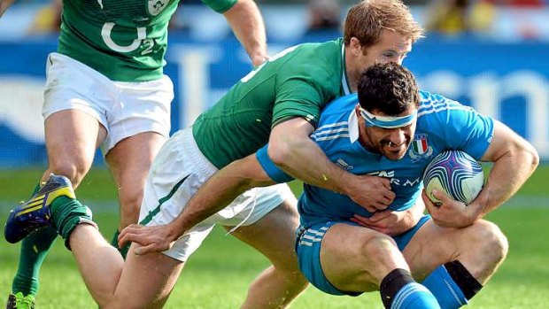 Italy's fullback Andrea Masi is driven back by Luke Fitzgerald.