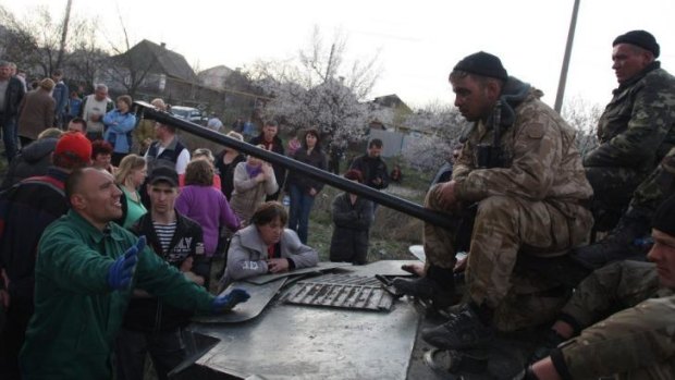 Ukrainian men sit on armoured personnel carriers as they are blocked by pro-Russia supporters in Kramatorsk.
