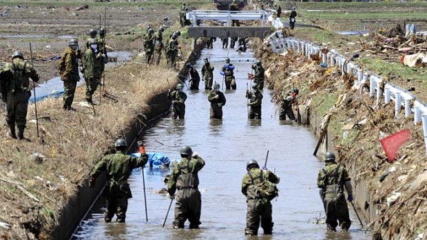 ''We want to return them to their families'' ... Japanese soldiers search for bodies in Miyagi Prefecture, north-eastern Japan.