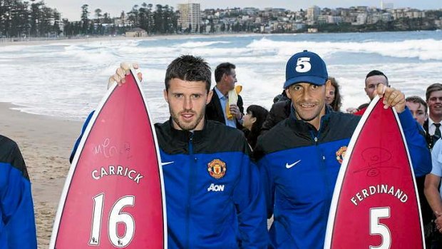 Board meeting: Michael Carrick and Rio Ferdinand of Manchester United wax lyrical with fans on Friday at a gloomy Manly beach where they were presented with customised surfboards to take home to sunny Blighty.