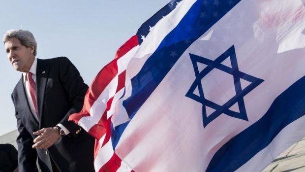 US Secretary of State John Kerry walks past US and Israeli flags at Ben Gurion International Airport in Tel Aviv on Monday.