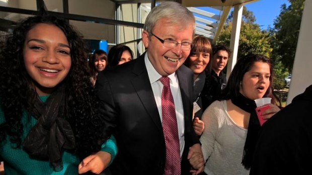 Linked in ... Kevin Rudd being escorted to his car by members of the National Indigenous Youth Parliament at Eagle Hawk Resort near Canberra.