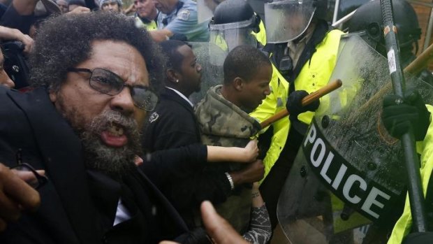 Rough treatment: Activist Cornel West is knocked over during a scuffle with police during a protest at the Ferguson Police Department.