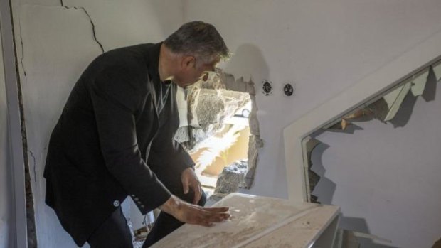 Israeli Finance Minister Yair Lapid inspects the damage inside a house following a rocket attack by militants from the Gaza Strip on the southern Israeli town of Sderot.