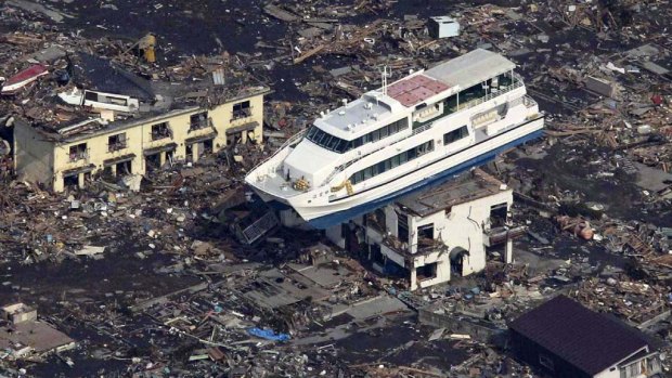 This aerial shot shows a pleasure boat sitting on top of a building amid a sea of debris in Otsuchi town in Iwate prefecture today.