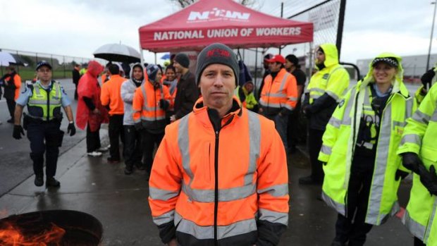 Picket line: Mark Judkins and other striking workers are watched by police at Coles' Somerton national distribution centre yesterday.