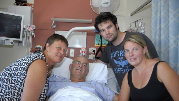 Brian Coker, who had both legs amputated in the Christchurch earthquake, in bed with his wife Helen with their children.