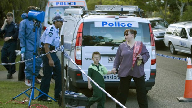 A woman tries to deliver flowers to the house in suburban Brisbane where two neglected children starved to death. PICTURE: EDDIE SAFARIK