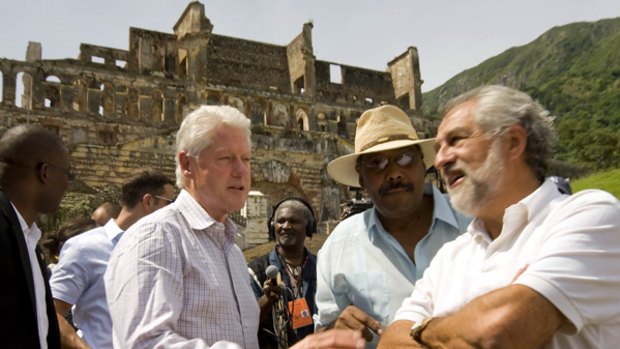 UN special envoy to Haiti and former US President Bill Clinton  speaks with a local businessman as he visits the ruins of Sans Souci palace.