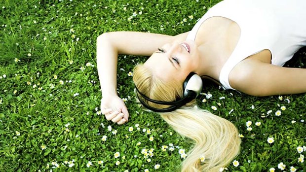 Woman lying on grass with headphones 