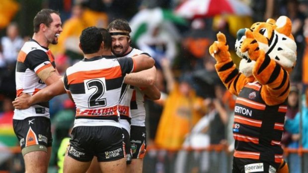Boilover: Front-rower Aaron Woods celebrates with teammates and the mascot after scoring in the Wests Tigers' big win over Manly at Leichhardt.