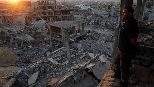 A Palestinian man looks out of his heavily damaged house at neighbouring houses which witnesses said were destroyed during the Israeli offensive, in the east of Gaza City.