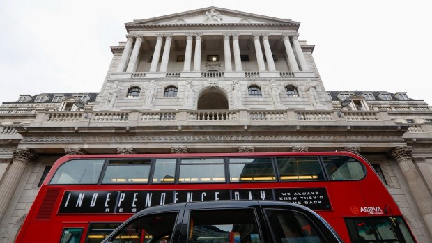 A London black taxi and a bus pass in front of the Bank of England in the City of London.