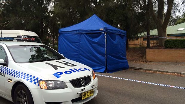 A car has been covered with a blue tent outside Gladesville police station.