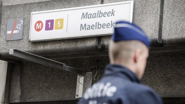 A Belgian police officer stands at the entrance to Maalbeek metro station in Brussels on Wednesday.