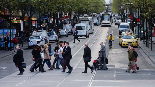 Pedestrians and cars mix it on Swanston Street.